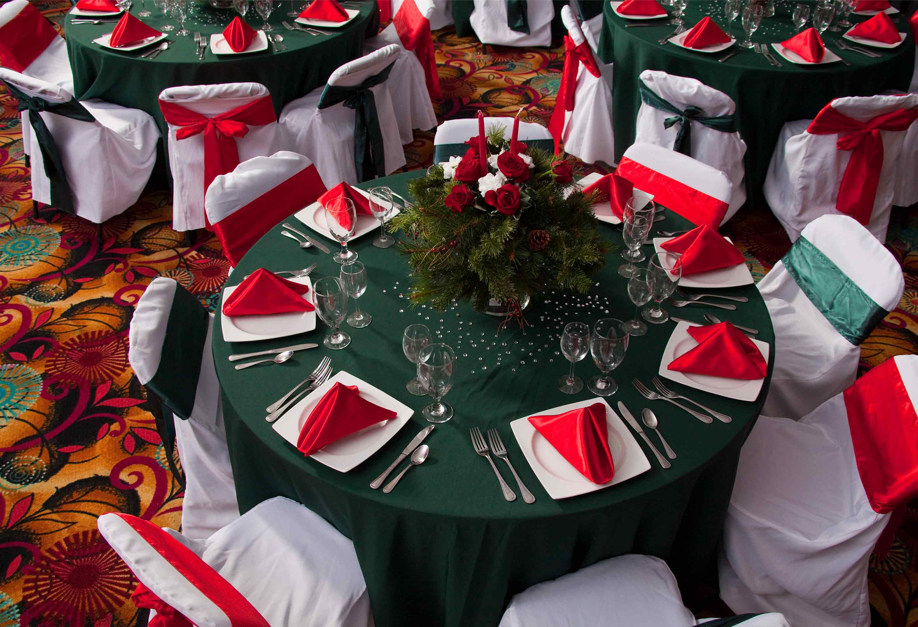 Holiday place settings on banquet tables in red and green