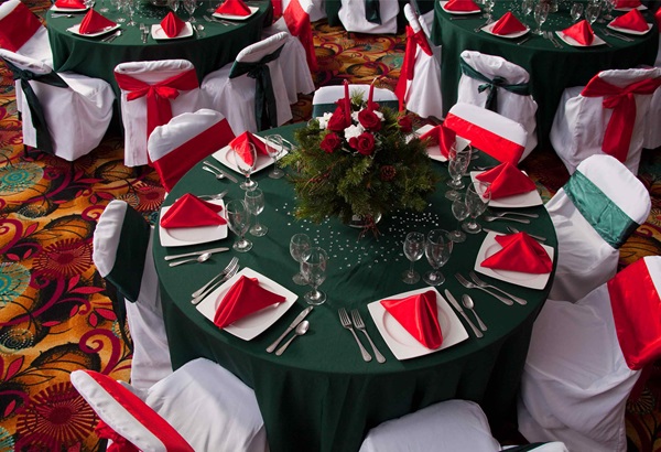 Holiday place settings on banquet tables in red and green