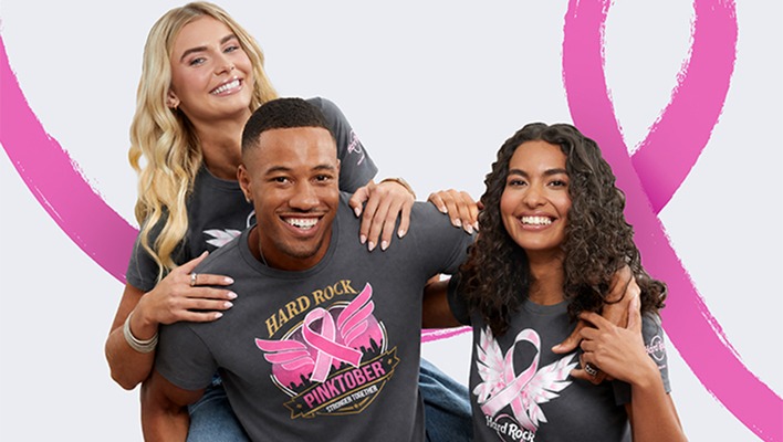 three people standing wearing Rock Shop PINKTOBER merchandise