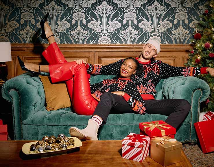 man and woman lounging on couch by christmas tree in Rock Shop holiday merch