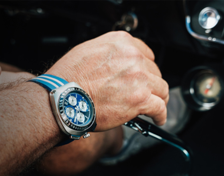 Man with watch driving a car
