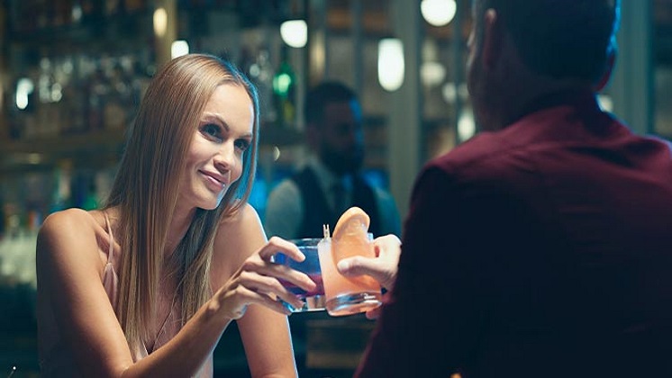 Woman Clinking Cocktail Glass with Man at The Rez Grill