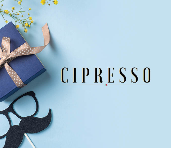 A Father's Day promotional image for Cipresso featuring a blue gift box with a tan polka-dot ribbon, decorative yellow wildflowers, and a novelty glasses-and-mustache photo prop on a light blue background, with the Cipresso logo